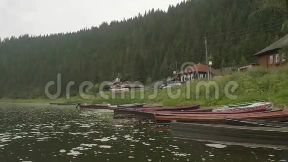 古老的俄罗斯村庄有古老的木屋小河两岸绿草如茵小船开着视频的预览图