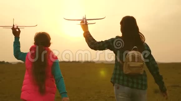 女孩们梦想着飞行成为一名飞行员和宇航员慢动作快乐的女孩姐妹带着玩具飞机在视频的预览图