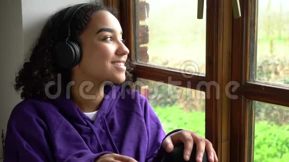 非裔美国少女通过无线蓝牙耳机和手机听音乐视频的预览图