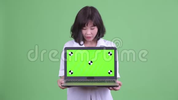 快乐美丽的亚洲女商人展示笔记本电脑看上去很惊讶视频的预览图