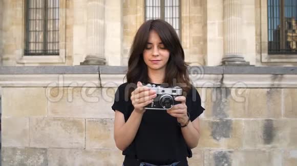 年轻的女人在拍电影摄影机的照片巴黎的旧建筑背景视频的预览图