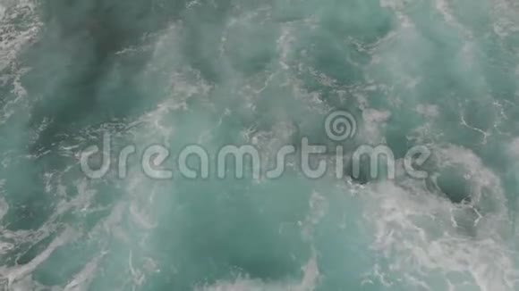 鸟瞰一个长而强大的波浪击中黑色海滩相机从下向上移动俯瞰悬崖视频的预览图