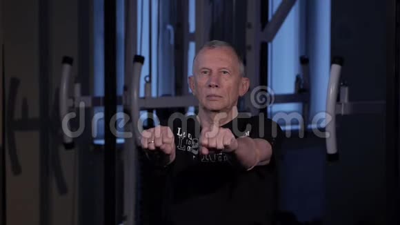 一个同龄的人在健身房为手指做关节体操握紧和松开你的拳头手臂伸出视频的预览图