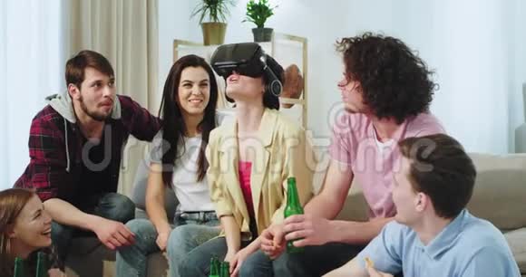 很有魅力的女士和她的朋友们在一起玩得很开心她用虚拟现实眼镜所有的朋友视频的预览图