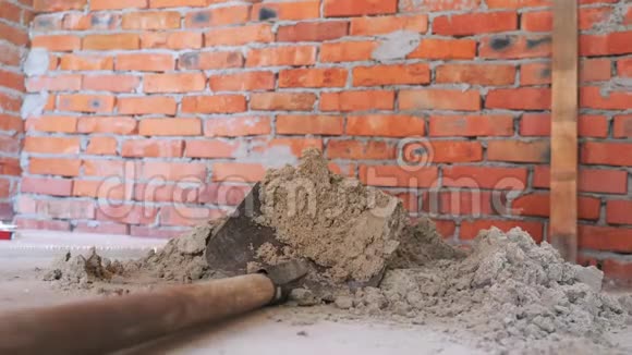 铲挖沙双手拿着铲子在红砖墙附近挖沙建设概念视频的预览图