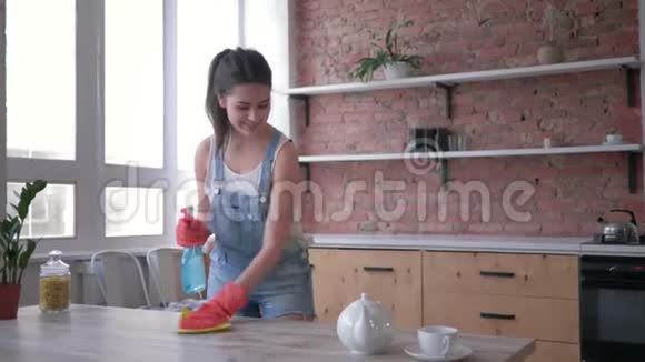 家务和家务漂亮的女人戴着手套用清洁剂喷雾和灰尘清除桌子然后看相机视频的预览图