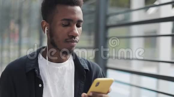 一个戴着耳机看智能手机的人视频的预览图