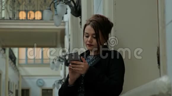 漂亮的中年黑发女人穿着黑色外套通过电话交谈视频的预览图