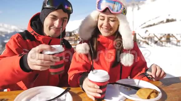两个滑雪者在山顶上休息和吃饭一对夫妇在外面的滑雪场喝酒吃午饭视频的预览图