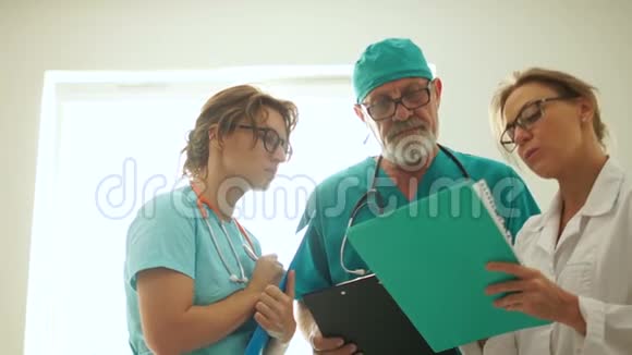 三位医生在一家急诊医院与窗户商量紧急情况紧急手术视频的预览图