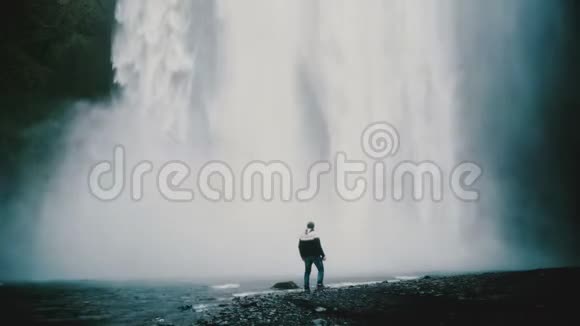 年轻的帅哥独自走在冰岛强大的Gljufrabui瀑布附近欣赏风景视频的预览图