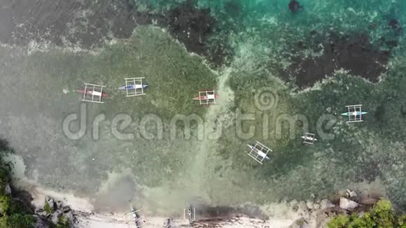 无人驾驶飞机在一片绿松石透明的海洋中拍摄渔船里面有珊瑚礁和深蓝色的中空视频的预览图