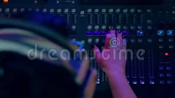 女子的手在混合控制台混合轨道迪斯科在彩色照明视频的预览图