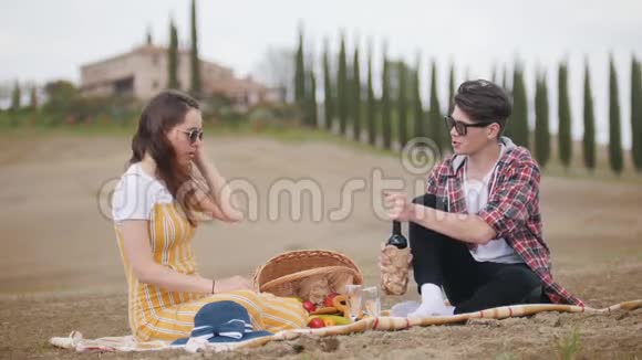一对年轻夫妇在野餐时在杯子里倒酒视频的预览图