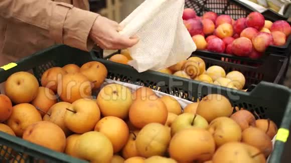 亲密的计划穿着雨衣的女人在超市或蔬菜店买苹果环保包装可重复使用视频的预览图