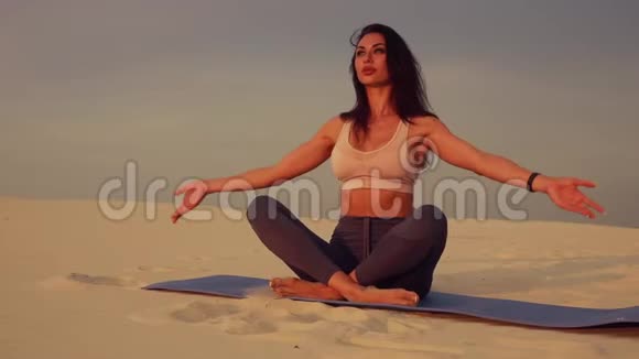 日落时分在沙漠中冥想瑜伽的女人视频的预览图