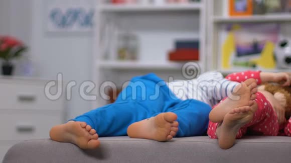男孩和女孩的腿躺在沙发上休息后积极休闲白天睡觉视频的预览图