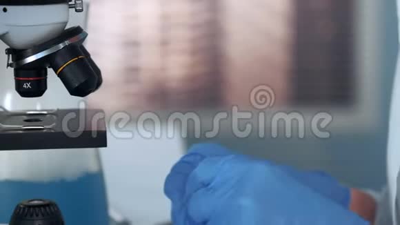 科学家双手将植物叶片置于显微镜下的特写镜头视频的预览图