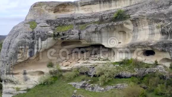 靠近岩石中的洞穴住宅坚不可摧的岩石上的古城堡垒视频的预览图