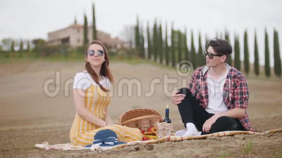 一对年轻夫妇在野餐聊天和吃水果托斯卡纳视频的预览图
