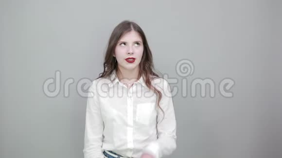时尚的漂亮女人穿着白色衬衫手牵着鼻子做着愚蠢的手势视频的预览图