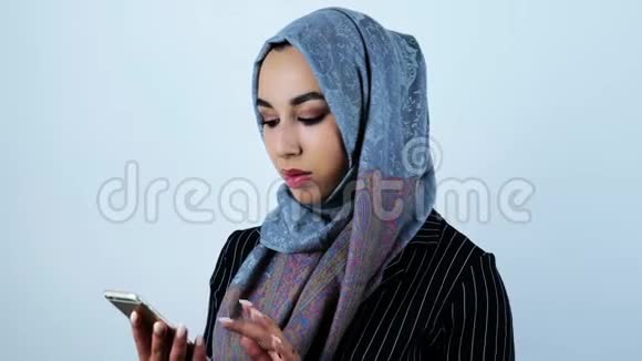 年轻美丽的阿拉伯女人拨打电话从智能手机上打电话给一个人视频的预览图