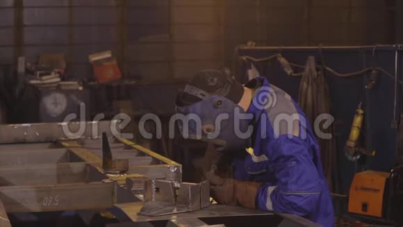 工厂工人慢动作焊接金属零件的过程视频的预览图