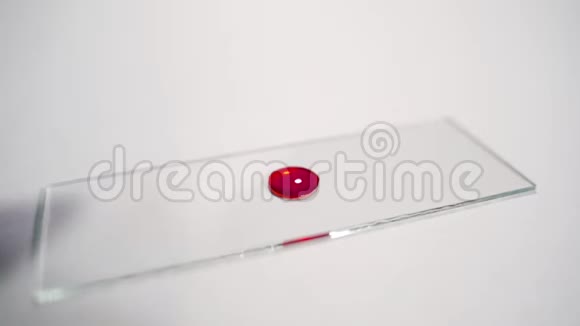 女化验员在实验室的吸管上缓慢移动的玻璃玻片上滴血手拿乳胶视频的预览图