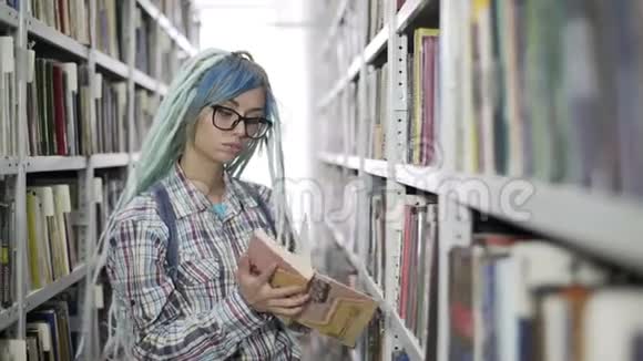希普斯特女学生戴着眼镜戴着可怕的眼镜在图书馆刻苦学习视频的预览图