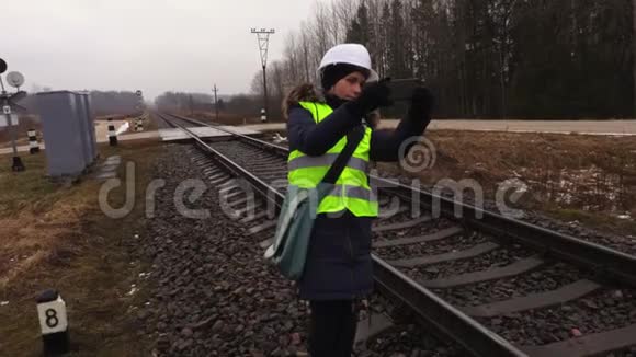 女铁路工程师在维修前给铁轨拍照视频的预览图