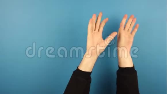 人手挥舞音乐节奏手势孤立在蓝色背景在演播室视频的预览图