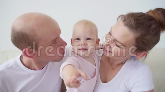 幸福的家庭观念父母亲吻婴儿微笑视频的预览图
