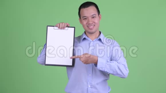 快乐的亚洲商人展示剪贴板竖起大拇指视频的预览图