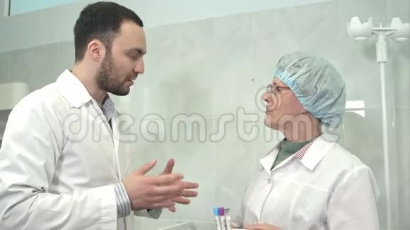 友好的男医生和拿血样的护士交谈视频的预览图
