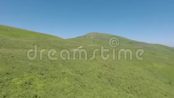 穿过山顶高山草地的路视频的预览图