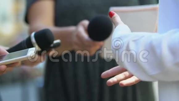 女性手势回答记者手持麦克风的问题视频的预览图