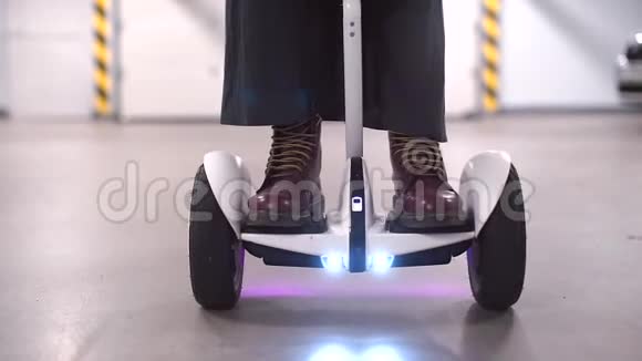 一个陀螺滑板车的特写镜头上面站着一个穿着长裙子和长靴的人视频的预览图