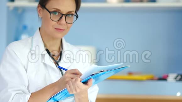可爱的女医生穿着白色外套和眼镜看着相机微笑着视频的预览图