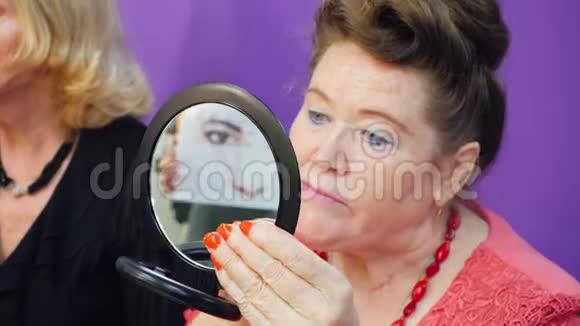 老年妇女照镜子用化妆刷化妆视频的预览图