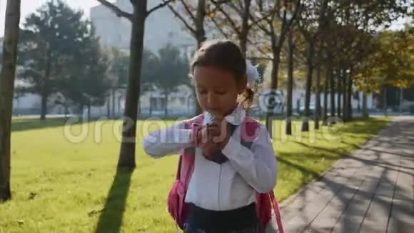 一个穿着校服的小女孩在智能手表上走来走去视频的预览图