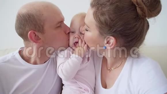 幸福的家庭观念父母亲吻婴儿微笑视频的预览图