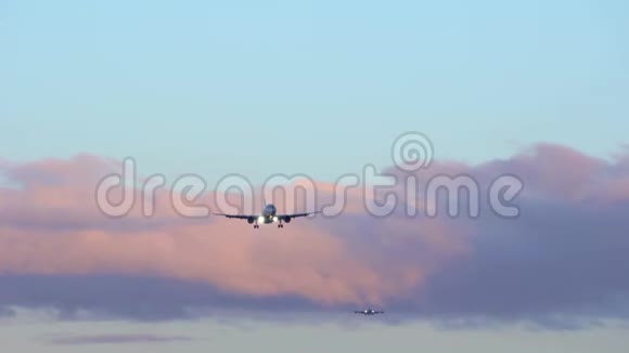 两架飞机在空中飞行在蓝蓝的天空中紫色的橙色云视频的预览图