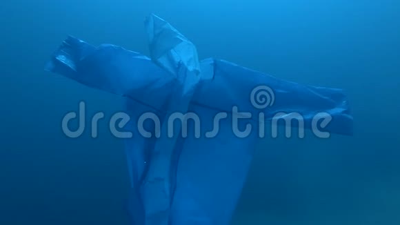 蓝色塑料雨衣作为幽灵慢慢漂浮在蓝色的水中海洋的水下塑料污染塑料垃圾视频的预览图