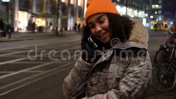 德国柏林Alexanderplatz车站的一名年轻女子夜间用手机与电车通话视频的预览图