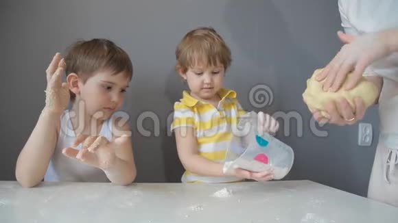 母亲儿子和女儿用手揉面团视频的预览图