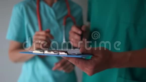 密切医生的手和文件医生在助手手中的医疗文件上签字视频的预览图