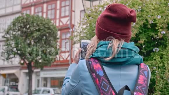 年轻的女游客在德国城市历史上的智能手机景点拍照慢动作特写视频的预览图