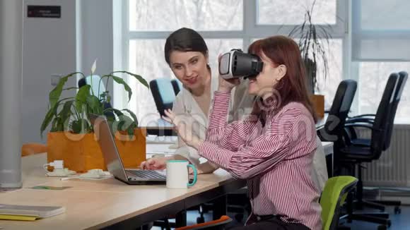 女商人与同事讨论虚拟现实护目镜视频的预览图