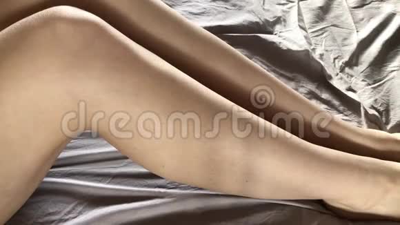 女人在腿上涂上清爽的奶油或身体乳液概念护肤品视频的预览图