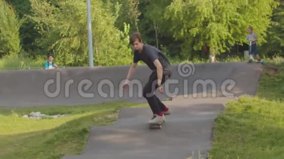 年轻人训练他的滑板技能在波浪形的马路上溜冰视频的预览图